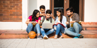 young-asian-indian-college-students-reading-books-studying-laptop-preparing-exam-working-group-project-while-sitting-grass-staircase-steps-college-campus 1